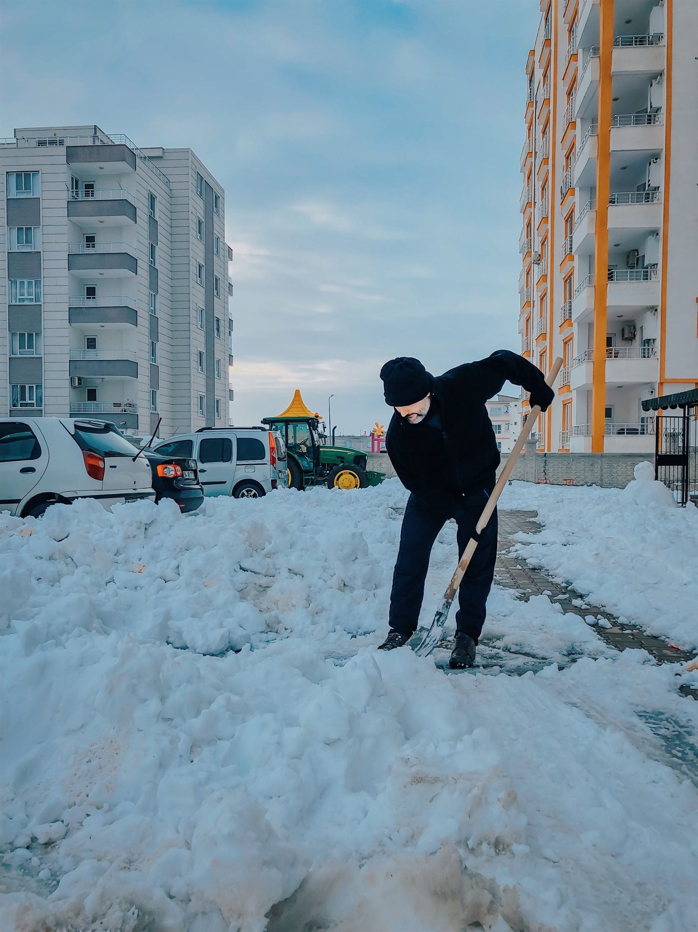 Travailleur déneigeant un trottoir à la pelle